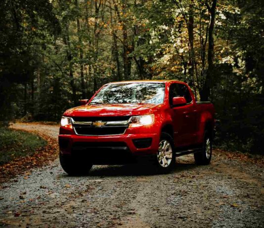 red chevy silverado on forest road